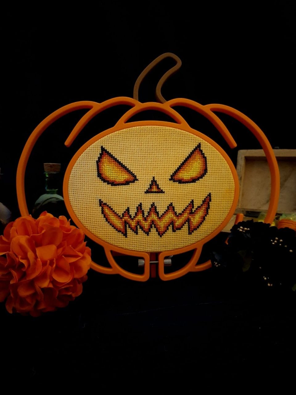 Halloween pumpkin cross-stitch pattern by Crossed Itch framed in a custom light-up Tiny Projectiles hoop