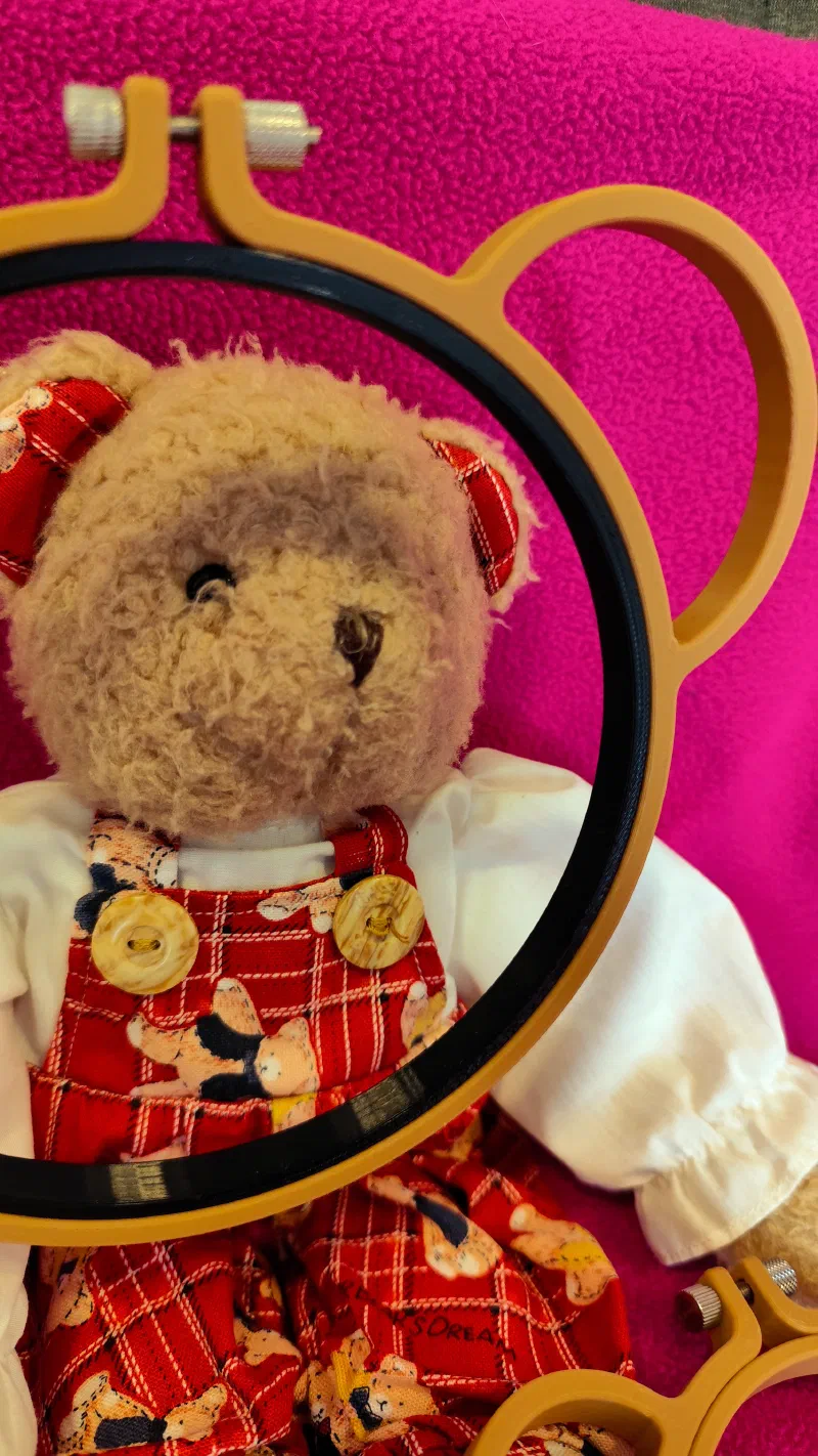 Close-up of a custom 3D printed bear style embroidery hoop in front of a cute teddy bear.