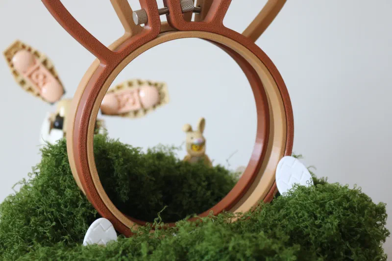 Close-up of a 3D printed bunny style embroidery hoop in front of a Lego bunny.