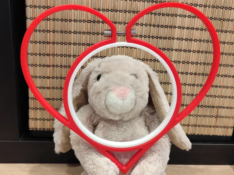Heart shaped 3D printed embroidery hoop in front plush bunny.